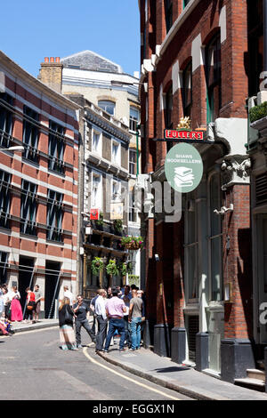 Menschen trinken außerhalb von Kneipen und Bars am St Andrew Hill, London, England Stockfoto