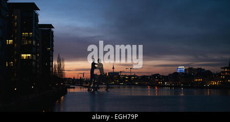 Berlin, Deutschland. 24. Februar 2015. Die drei-Personen-Skulptur "Molecule Man" steht in der Spree bei Sonnenuntergang in Berlin, Deutschland, 24. Februar 2015. Foto: Felix Zahn/Dpa/Alamy Live News Stockfoto