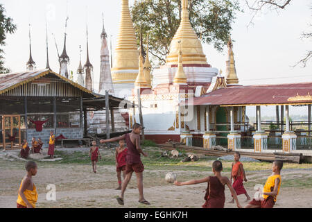 Unerfahrene junge Mönche spielen Fußball in ihren Gewändern im Freien in ihr Kloster am Ufer des Inle-See, Burma, Myanmar. Stockfoto