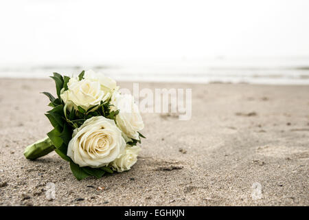 Brautstrauß aus weißen Rosen am Nordseestrand liegen Stockfoto