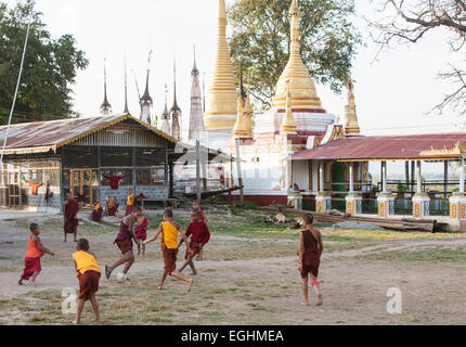 Unerfahrene junge Mönche spielen Fußball in ihren Gewändern im Freien in ihr Kloster am Ufer des Inle-See, Burma, Myanmar. Stockfoto