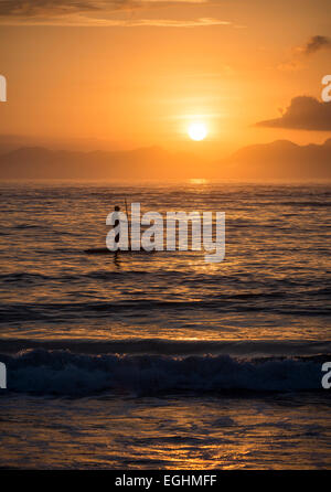 Mann-Paddle-boarding am Copacabana-Strand bei Sonnenaufgang Rio De Janeiro, Brasilien, Südamerika Stockfoto