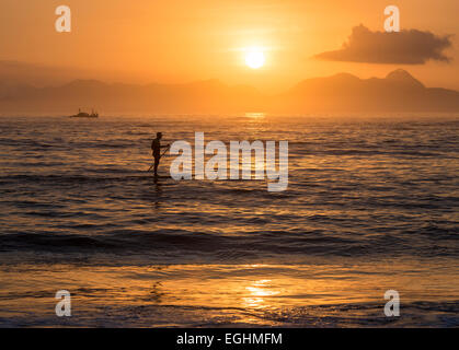 Mann-Paddle-boarding am Copacabana-Strand bei Sonnenaufgang Rio De Janeiro, Brasilien, Südamerika Stockfoto