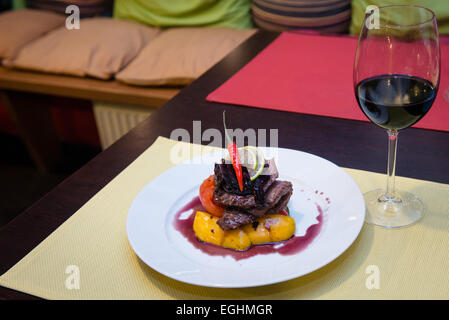 Köstliches geschmortes Rindfleischsteak mit gegrilltem Gemüse und roter Zwiebelsauce Stockfoto