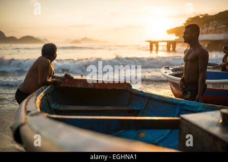 Fischer ihre Boote herausnehmen, bei Dämmerung, die Copacabana, Rio De Janeiro, Brasilien Stockfoto