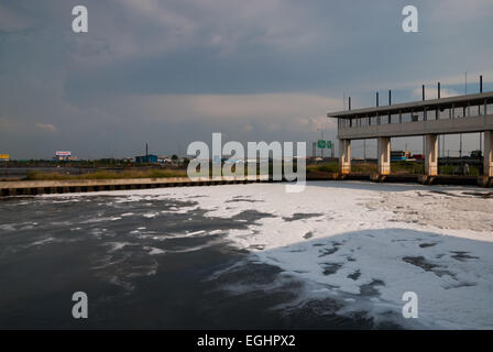 Weiße Schäume bedecken einen Wasserweg in der Nähe eines Teils der Autobahn, die zum internationalen Flughafen Soekarno-Hatta in Jakartas Küstengebiet führt. Stockfoto