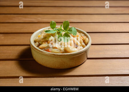 Pikante spanische Bohnen-Eintopf mit Gemüse in einer Schüssel braun Terra Cotta. Fabada Asturiana. Stockfoto