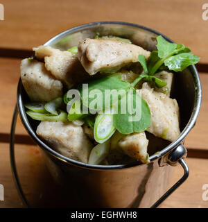 Tapas leicht gewürzten Hähnchenstreifen mit Frühlingszwiebeln. In einem Eimer Form Stahl Schüssel serviert Stockfoto