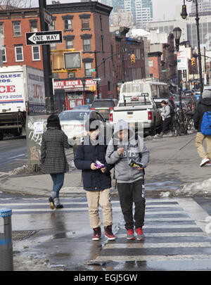 Pre-teen-Boys snack als sie nach Hause nach der Schule entlang Smith Street im Stadtteil Carroll Gardens of Brooklyn, NY gehen. Stockfoto