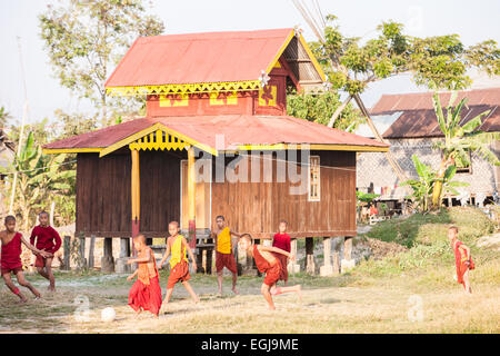 Unerfahrene junge Mönche spielen Fußball in ihren Gewändern im Freien in ihr Kloster am Ufer des Inle-See, Burma, Myanmar. Stockfoto