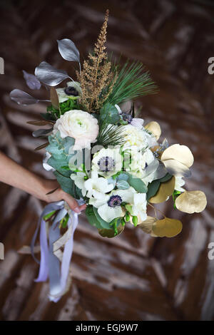 Ungewöhnliche Hochzeit Bouquet mit Ranunkeln, Freesien, Rosen und weißen Anemone im retro-Stil in Händen einer Braut Stockfoto