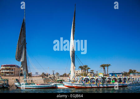 Bunte Fähren und Feluken vertäut am Westufer warten auf Touristen über den Nil nach Luxor zu nehmen. Stockfoto