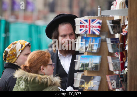 Jüdischen Touristen betrachten Postkarten aus London an einem Kiosk in Westminster, London, UK Stockfoto