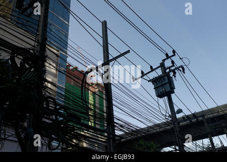 Chaotisch unordentlich Überlandleitungen elektrischen Nachrichtenkabeln in Bangkok Thailand Asien Stockfoto