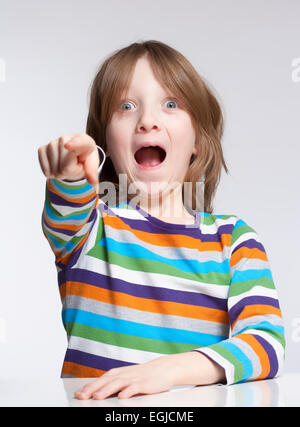 Junge mit blonden Haaren zeigt mit seinem Mund offen Stockfoto