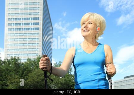 Eine ältere Frau, Nordic-walking im Freien zu tun Stockfoto