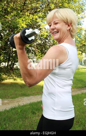 Eine ältere Frau outdoor-Training mit Hantel Stockfoto