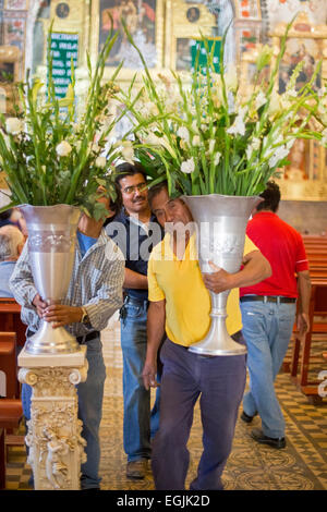 Tlacochahuaya, Oaxaca, Mexiko - Arbeiter legen Sie Blumen für eine Beerdigung in das Heiligtum der Kirche San Jeronimo. Stockfoto