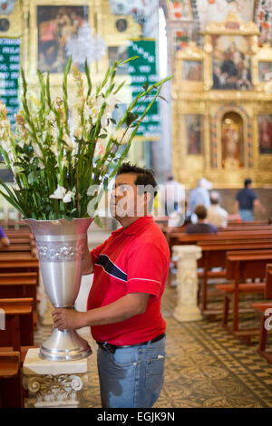 Tlacochahuaya, Oaxaca, Mexiko - Arbeiter legen Sie Blumen für eine Beerdigung in das Heiligtum der Kirche San Jeronimo. Stockfoto