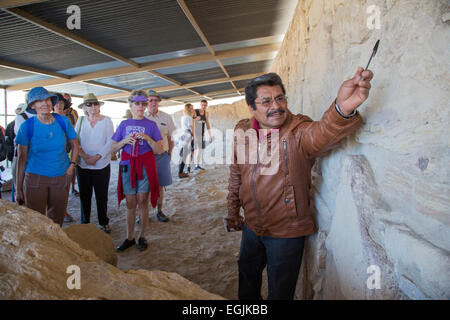 Tlacochahuaya, Oaxaca, Mexiko - erzählt eine Anleitung Besucher auf einer Felswand auf die archäologische Stätte von Dainzu geschnitzten Figuren. Stockfoto