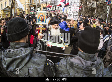 25. Februar 2015 - der Priester im Gespräch mit der Polizei bei einer Kundgebung "Rechten Sektor" in der Nähe der ukrainischen Präsidentschaftswahlen Verwaltung. -Ukrainische radikale Organisation '' rechten Sektor '' statt auf Mittwoch, 25. Februar 2015, in Kiew '' Wahrheit Marsh - Marsh Rechte." Radikale beschuldigen ukrainische Behörden in wirtschaftliche Probleme, Korruption und Fehler des speziellen Vorgangs im Osten. Bei Anti-Terror-Operationen und auf dem Maidan und die schwarzen und roten Fahnen getragen Aktivisten Porträts von Menschen, die getötet wurden. © Igor Golovniov/ZUMA Draht/Alamy Live-Nachrichten Stockfoto