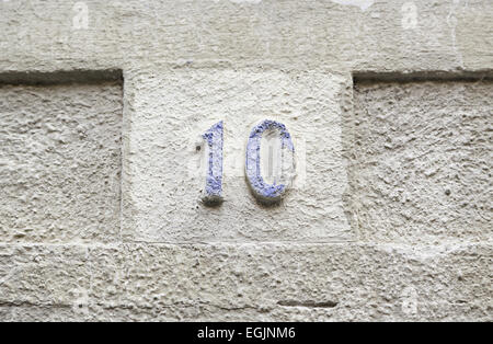 Nummer zehn auf einer Steinmauer, Detail einer Reihe von Informationen über eine Mauer in der Stadt, antike und alte Stockfoto