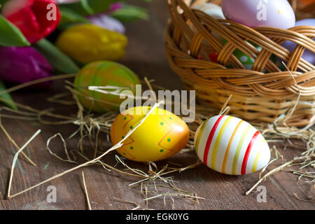 Ostereier und Tulpen auf Holzbrett Konzept Stockfoto