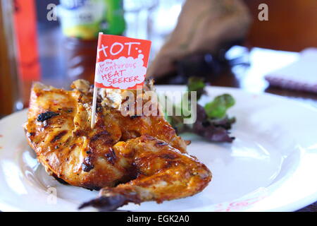 Nandos Hähnchenflügel mit Salat auf einem Teller Stockfoto