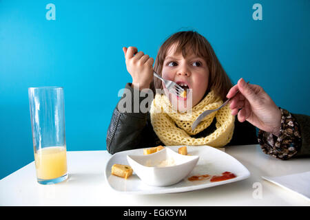 Sechs Jahre alter Junge Grimasse während des Essens "Patatas Bravas" in einem Restaurant in Barcelona, Spanien. Stockfoto