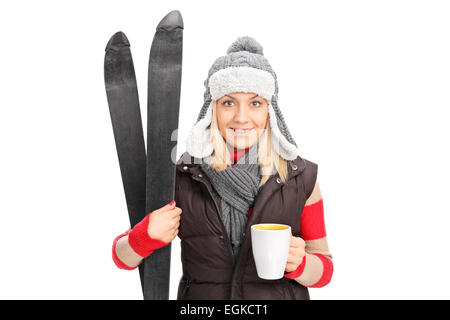 Frau hält ein paar Ski und trinken heißen Tee isoliert auf weißem Hintergrund Stockfoto