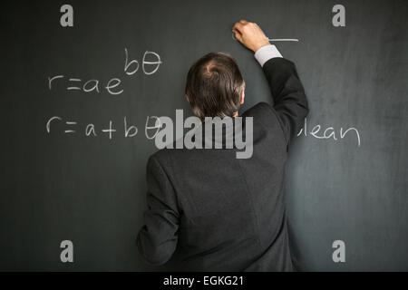 Männliche Oberlehrer Mathematikunterricht, an die Tafel schreiben Stockfoto