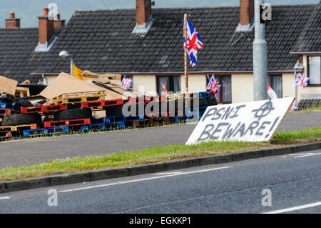 Newtownabbey, Nordirland. 10. Juni 2013. Schilder mit Bedrohungen PSNI, einschließlich Pistole Fadenkreuz erscheinen eine Loyalist Lagerfeuer Sammelstelle in Rathcoole. Stockfoto