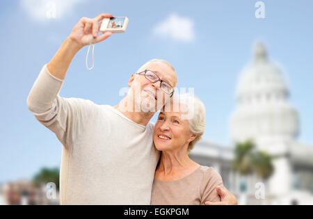 Älteres Paar mit Kamera über weiße Haus Stockfoto