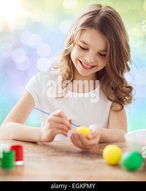 glückliches Mädchen mit Pinsel Ostereier färben Stockfoto