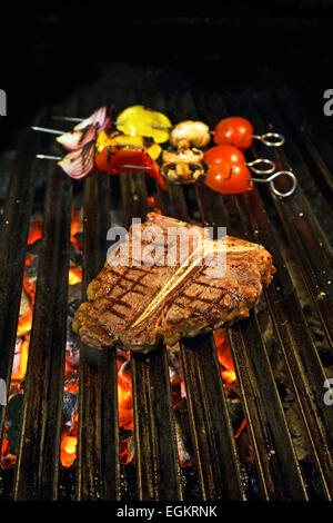 T-Bone Steak auf dem Grill mit Gemüse Speeren im Hintergrund Stockfoto