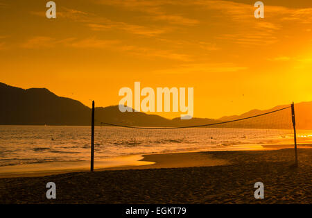 Ein dramatischer Sonnenuntergang Silhouetten einen Beach-Volleyball net in Miramar Beach in der Nähe von Manzanillo, Colima, Mexiko Stockfoto