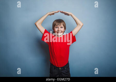 Junge, Jugendliche, zwölf Jahre im roten T-shirt, machte seine Hände ein