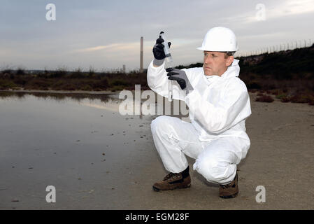 Arbeiter in einem Schutzanzug Prüfung Verschmutzung im Wasser in der Industrie. Stockfoto