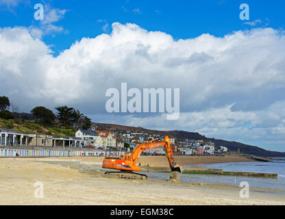 Nivellierung des Strands bei Lyme Regis mit einem JCB Bagger, Dorset, England UK Stockfoto