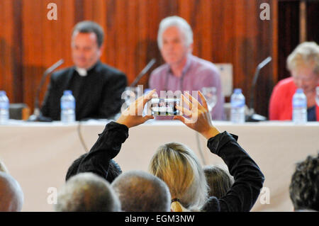 Eine Frau benutzt ihr Handy ein Foto von der Jury in einem politischen Gremium Talkshow zu nehmen. Stockfoto