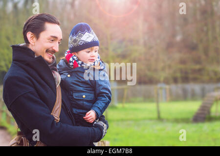 Vater Hodling seinen Sohn in den Armen und lächelnd Stockfoto