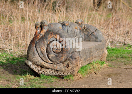 Schnecken in einer Holzbank Log-Park geschnitzt Stockfoto