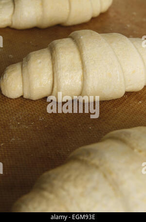 ungekocht Croissants auf ein Backblech Matte im Ofen einsatzbereit Stockfoto