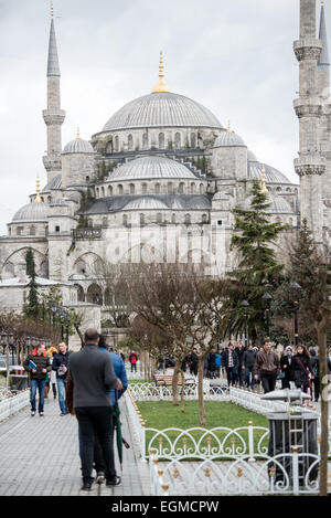 Blaue Moschee Sultan Ahmed Moschee Istanbul Türkei // ISTANBUL, Türkei — Touristen auf dem platz zwischen der Blauen Moschee und der Hagia Sophia im Stadtteil Sultanahmet von Istanbul. Obwohl die Moschee wegen ihrer Innenverkleidung weithin als Blaue Moschee bekannt ist, lautet der formale Name der Moschee Sultan Ahmed Moschee (oder Sultan Ahmet Camii auf Türkisch). Sie wurde von 1609 bis 1616 unter Sultan Ahmed I. erbaut Stockfoto