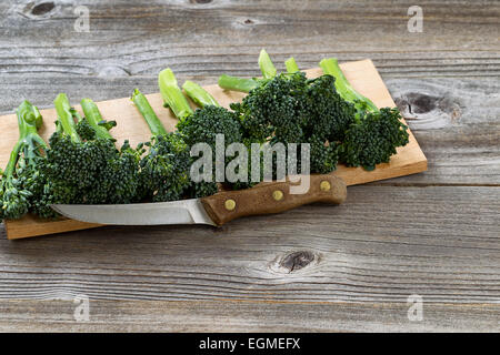 Vorderansicht des ein Vintage einzigen Schneidmesser vor frischem grünem Gemüse mit rustikalen Holzbretter unter. Stockfoto