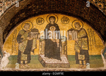 ISTANBUL, Türkei / Türkije — Ein Mosaik, das die Jungfrau Maria und das Kind darstellt, flankiert von Justinian I. und Konstantin I. in Hagia Sophia. Aus dem 10. Jahrhundert. Auf der rechten Seite befindet sich Kaiser Konstantin mit einem Modell der Stadt Konstantinopel. Auf der linken Seite befindet sich Kaiser Justinian mit einem Modell der Hagia Sophia. Ursprünglich im Jahr 537 erbaut, diente sie als östlich-orthodoxe Kathedrale, römisch-katholische Kathedrale, Moschee und heute als Museum. Auch bekannt als Ayasofya oder Aya Sofia, ist es eines der wichtigsten Wahrzeichen Istanbuls. Stockfoto