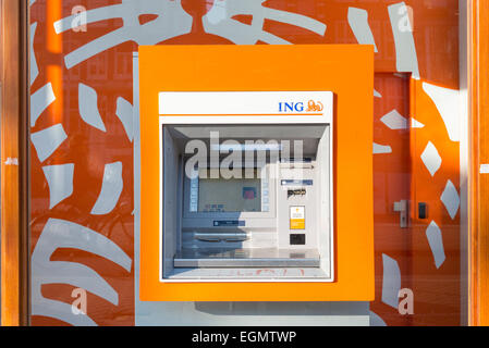 Ein helles orange ING ATM-Maschine in der Wand der ING Bank. Teil des Arbeitskreises Intenational Niederlande Stockfoto