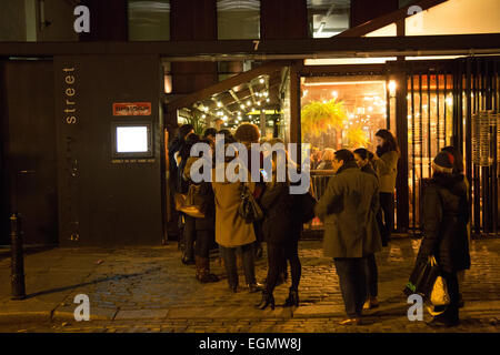 Eine Warteschlange von Diners außerhalb des beliebten Dishoom indischen Restaurants, auf Boundary Street, Shoreditch, London UK Stockfoto