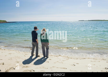 Junge Frau und Mann an einem schönen Sandstrand im Sommer Sonnenschein, Orkney Inseln, Schottland. Stockfoto