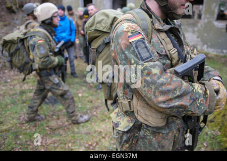 Truppen des 26. Luftlandebrigade sichern eine Gruppe von Extras, die als evakuierte während der Pulsar-Manöver der Bundeswehr in der Nähe von Wallerfangen, Deutschland 26. Februar 2015 darstellen. Die deutsche Armee führt Übungen mit rund 450 Soldaten mit Schwerpunkt auf die Evakuierung von Volksdeutschen aus Konfliktgebieten. Foto: Oliver Dietze/dpa Stockfoto